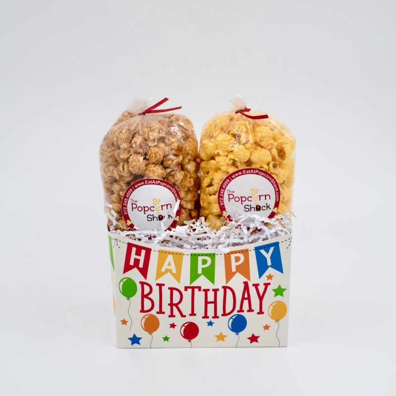 Cream-colored basket with Happy Birthday flags draped across the top, surrounded by balloons and stars.