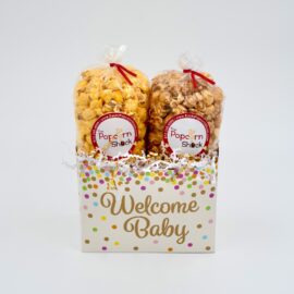 Baby gift basket with cream-colored background, gold lettering, and colored dots, suitable for two bags of popcorn.