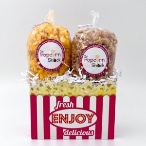 Two bags of popcorn in a box with the old-style red and white vertical stripes reminiscent of the old movie theater popcorn bags.